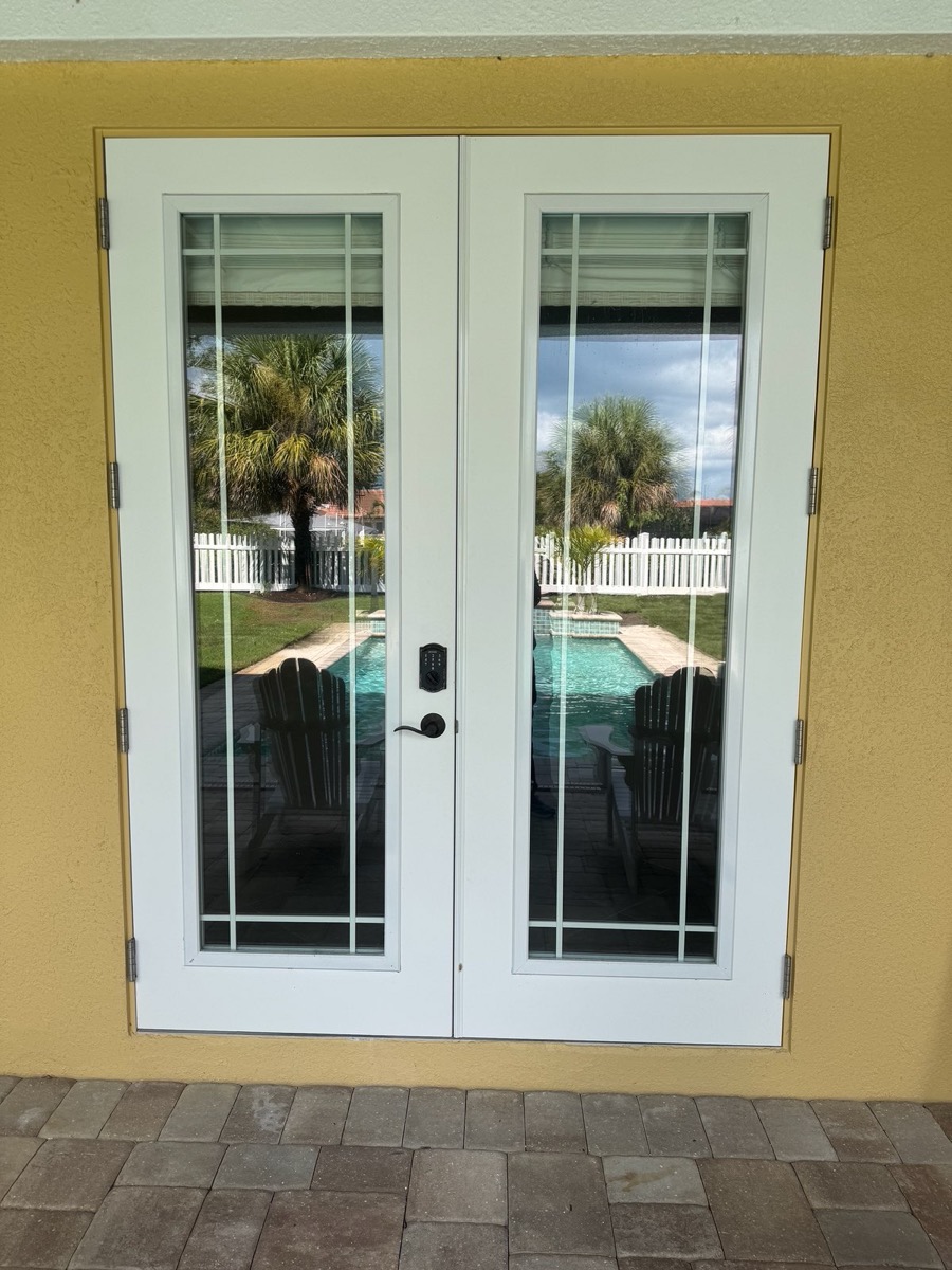 Impact French doors with pool view installed by Cat 5 Protection